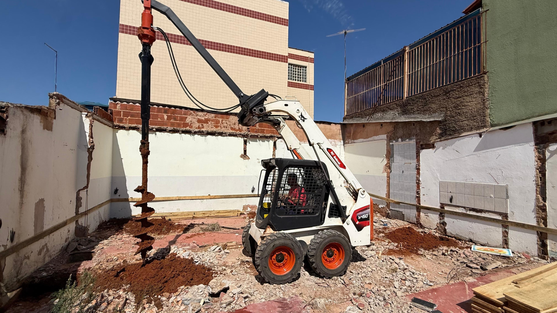 Minicarregadeira Bobcat realizando terraplanagem e limpeza em Brasília